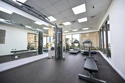 a gym with treadmills and ellipticals in a building at Stylish 1BR Apartment - Central Location in JVC - Balcony - Holiday Boulevard in Dubai
