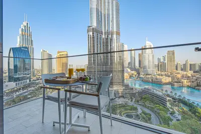 a balcony with a table and chairs and a view of a city at Venetian - Stay at Address Opera with Burj & Fountain views in Dubai