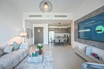 a living room with a couch and a flat screen tv at Venetian - Refined 2BR at Grande Tower, Burj & Fountain views in Dubai