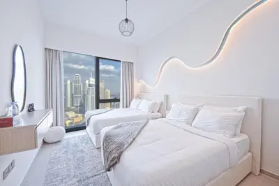 two beds in a hotel room with a large window at Venetian - Refined 2BR at Grande Tower, Burj & Fountain views in Dubai