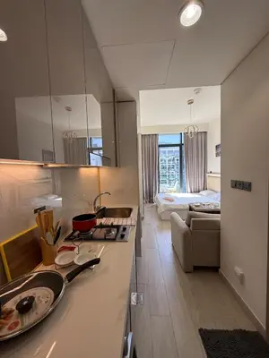 a kitchen with a counter top and a living room at Azizi Rivera 33 in Dubai