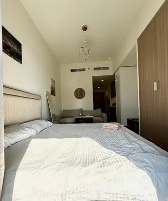 a large bed in a bedroom with a couch at Azizi Rivera 33 in Dubai