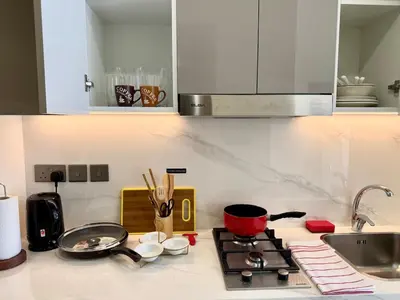 a kitchen counter with a stove and a sink at Azizi Rivera 33 in Dubai