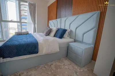 a bedroom with a large bed and a window at Dunya Tower Royal suites in Dubai