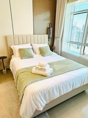 a bedroom with a large bed with towels on it at Lake City Tower in Dubai