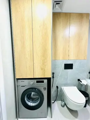 a bathroom with a washing machine and a toilet at Lake City Tower in Dubai