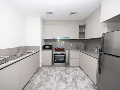 a large kitchen with white cabinets and appliances at Beachfront Family Entire Unit in Dubai Ras Al-Khor in Dubai