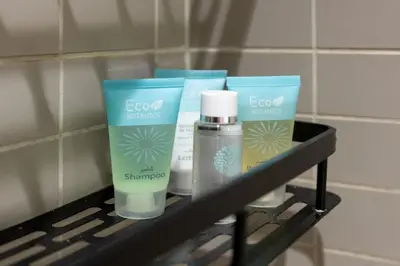 a shelf with some soap and other products on it at Silverene Tower - One Bedroom By Home Of Choice in Dubai