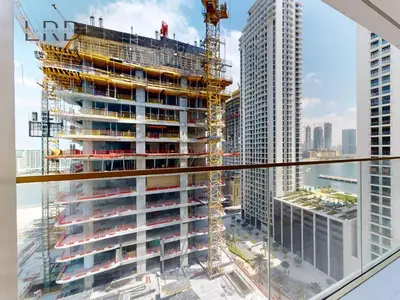 a tall building under construction with a crane at Waterfront 1 Bedroom Apartment - Private Beach - Emaar Beachfront in Dubai