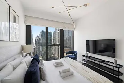 a living room with a white couch and a tv at Silkhaus Serene 1BR at Boulevard Heights in Downtown in Dubai