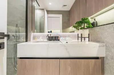 a bathroom with a white sink and a shower at Near Dubai Miracle Garden Studio with Community Views Balcony, Legacy by Sunrise, Arjan-Dubailand by Deluxe Holiday Homes in Dubai