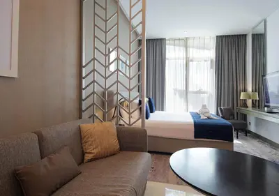 a hotel room with a bed and a couch at Stylish Studio Apartment in Dubai with Pool & Gym in Dubai