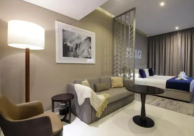 a living room with a couch and a bed at Stylish Studio Apartment in Dubai with Pool & Gym in Dubai