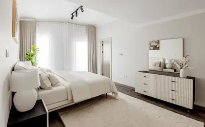 a white bedroom with a bed and a mirror at Beautiful 3 bed In Dubai Marina! in Dubai