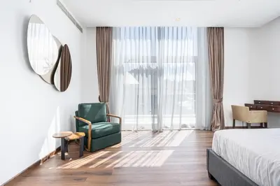 a bedroom with a green chair and a bed and a mirror at Palm Home next to Nakheel Mall with Private Beach in Dubai