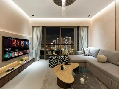 a living room with a couch and a tv at Crown Jewel 2 Bedroom Apartments I Iconic Burj Khalifa and Fountain Views I Free Parking, Gym, Pool, Wi-Fi and PS5 I by Skyline Serenity in Dubai