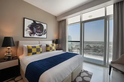 a bedroom with a bed and a large window at EasyGo- Sleek Studio at Damac Hills Artesia D in Dubai