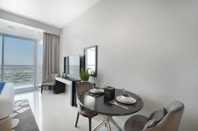 a living room with a black table and chairs at EasyGo- Sleek Studio at Damac Hills Artesia D in Dubai
