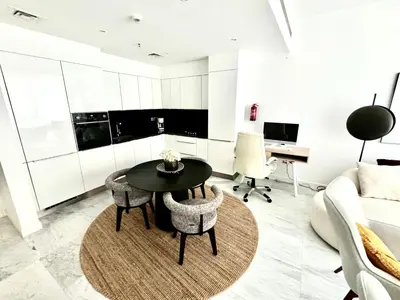 a living room with a table and chairs and a couch at The Pad by Omniyat in Dubai