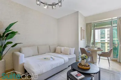 a living room with a white couch and a table at Stylish 1 Bedroom near metro station in JLT in Dubai