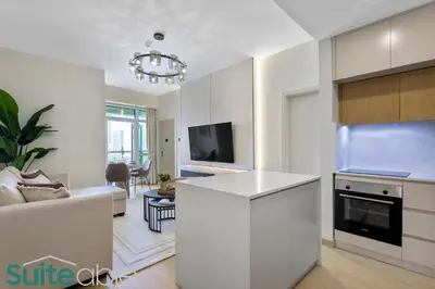 a kitchen and living room with a couch and a tv at Stylish 1 Bedroom near metro station in JLT in Dubai