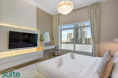 a bedroom with a large bed and a large tv at Stylish 1 Bedroom near metro station in JLT in Dubai