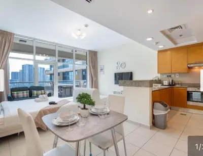 a kitchen and a living room with a dining room table at Business Bay Mahek Holiday Home in Dubai