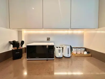 a kitchen counter with a microwave and appliances on it at Modern 2BR Skyline & Marina View in Dubai