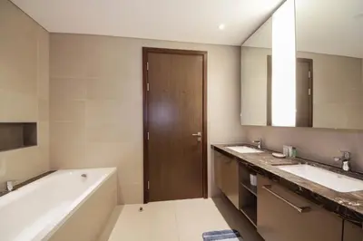 a bathroom with two sinks and a bath tub and a mirror at Spacious 2BHK Boulevard Heights Downtown in Dubai