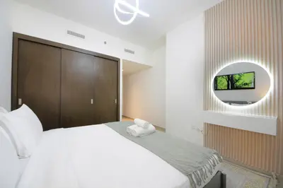 a bedroom with a white bed and a round mirror at Spacious 2BHK Boulevard Heights Downtown in Dubai