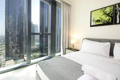a bedroom with a bed and large windows at Spacious 2BHK Boulevard Heights Downtown in Dubai