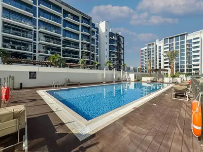 a large swimming pool in front of some buildings at Sleek Studio in Azizi Riviera Modern and Cozy Stay in Dubai
