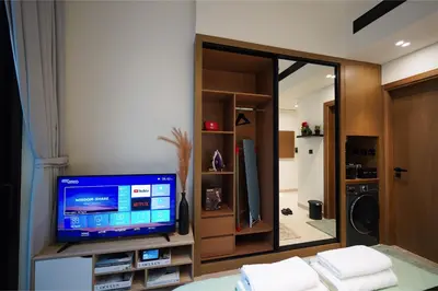 a living room with a tv and a mirror at PurityStaysDXB in Dubai