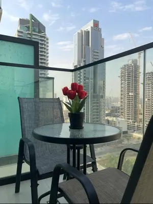a table with a vase of flowers on a balcony at PurityStaysDXB in Dubai