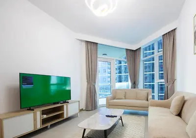 a living room with a television and a couch at Luxury 2BR Apartment in Urban Oasis by Missoni in Dubai