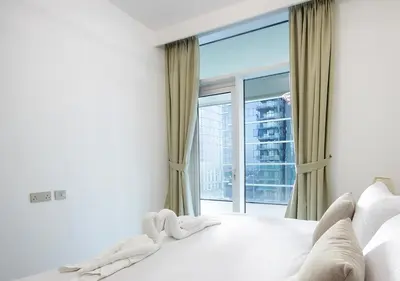 a bedroom with a bed with a large window at Luxury 2BR Apartment in Urban Oasis by Missoni in Dubai