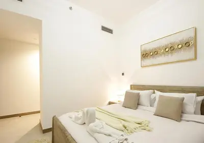a bedroom with a large bed with white sheets and pillows at Luxury 2BR Apartment in Urban Oasis by Missoni in Dubai