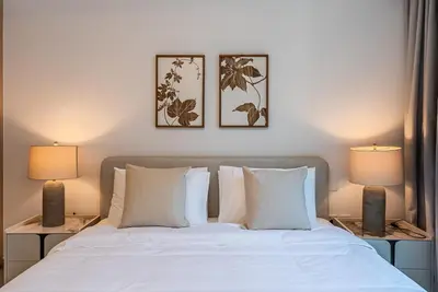 a bedroom with a white bed with two lamps at Luxurious 1BDR apartment in MBR City in Dubai