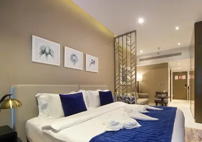 a bedroom with a large bed with blue and white pillows at Breathtaking Views Studio Apartment in Damac Prive in Dubai