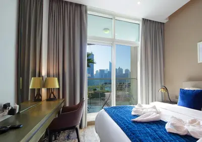 a hotel room with a bed and a desk and a window at Breathtaking Views Studio Apartment in Damac Prive in Dubai