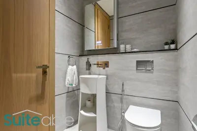 a bathroom with a toilet and a sink and a mirror at Aesthetic Studio with Stunning Pool View in JVC in Dubai
