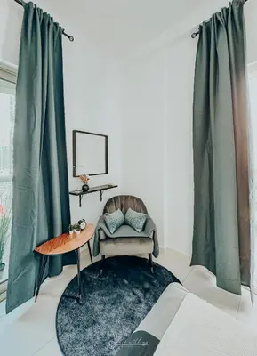 a living room with a chair and a table at LivWithUs - 2 BR in Marina View Tower B in Dubai