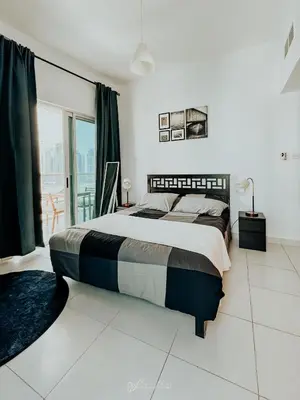 a bedroom with a large bed and a balcony at LivWithUs - 2 BR in Marina View Tower B in Dubai