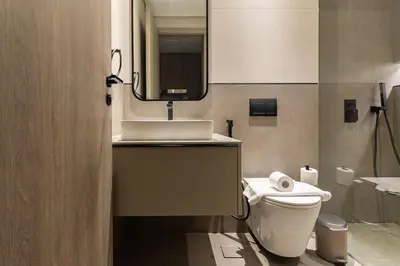 a bathroom with a toilet and a sink and a mirror at Modern Studio Apartment JVC in Dubai