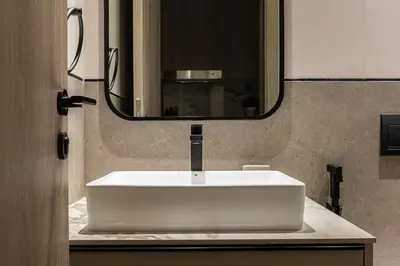 a white sink in a bathroom with a mirror at Modern Studio Apartment JVC in Dubai