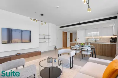 a living room with a couch and chairs and a kitchen at Sophisticated 1 Bedroom in Binghatti Galaxy JVC in Dubai