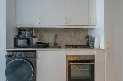 a kitchen with a washing machine and a microwave at Central Apartment in Dubai Heart in Dubai