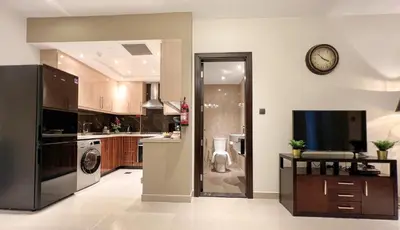 a large kitchen with a clock on the wall at 1BDR with Burj Khalifa Views in Elite Downtown in Dubai