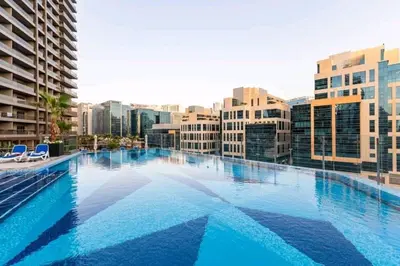 a large swimming pool in a city with buildings at 1BDR with Burj Khalifa Views in Elite Downtown in Dubai