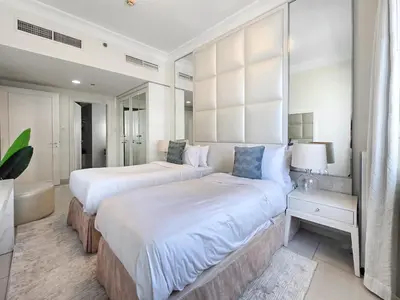 two beds in a large bedroom with white walls at EasyGo - Chic 1BR in Damac Maison in Dubai